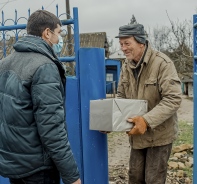 Der Schweizer Projektleiter u?berreicht Volodja in Moldawien ein Pa?ckli.